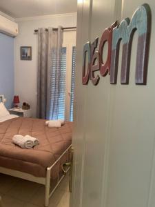 a bedroom with a bed and a sign that reads death at dimitris house 2 in Alepou