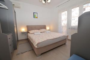 a bedroom with a large bed in a room with windows at M&N Apartment in Rovinj