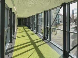 un pasillo vacío de un edificio de oficinas con ventanas en Jugendherberge Braunschweig en Brunswick