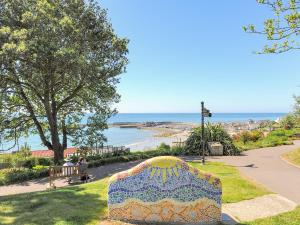a bench in a park with a view of the ocean at The Lymings in Lyme Regis