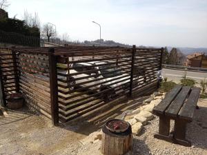 a wooden fence with a bench in front of it at La Tana dello Scoiattolo in Murazzano