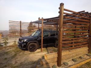 a black truck parked under a wooden fence at La Tana dello Scoiattolo in Murazzano
