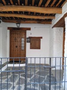 a room with a wooden door and a balcony at Casa Los Trillizos in Pampaneira