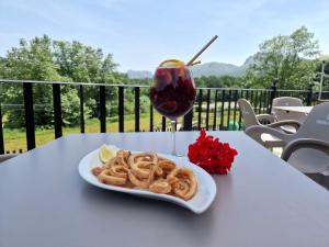 einen Teller Zwiebelringe und einen Drink auf dem Tisch in der Unterkunft CAMPING RAMALES in Ramales de la Victoria