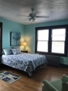 a bedroom with a bed and two windows at Old Time Beach Front Cottage - The Beach is your Backyard! Pet Friendly cottage in North Camellia Acres