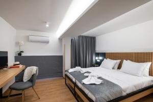 um quarto com uma cama, uma secretária e uma cadeira em Traveleclectic Apartments em Corfu Town