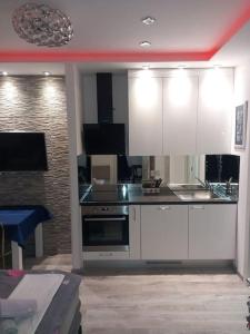 a kitchen with white cabinets and a stove at Mitella studio apartman in Solin