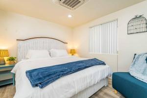 a bedroom with a large bed and a blue chair at NEW Charming Country Style 3B2B in Glendora