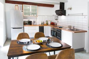a kitchen with a wooden table with plates and bowls of fruit on it at La couronne Maison 80m2 garage & terrasse in Sainte-Croix-en-Plaine