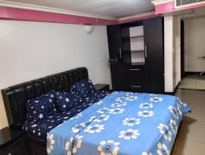 um quarto com uma cama com um cobertor azul e almofadas em Golden tulips festival mall em Lagos