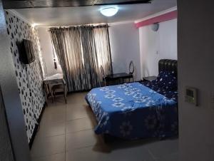 um quarto com uma cama, uma mesa e uma secretária em Golden tulips festival mall em Lagos