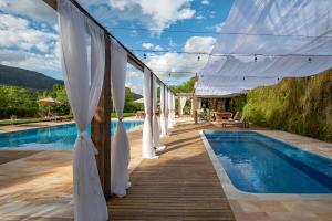 - une rangée de parasols blancs à côté d'une piscine dans l'établissement Pousada Brisa da Serra, à Tiradentes