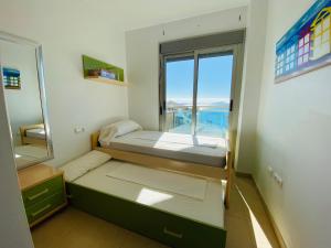 Cette petite chambre comprend un lit et une fenêtre. dans l'établissement Libertad Dos Playas, à La Manga del Mar Meno