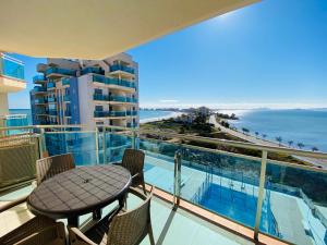 een balkon met een tafel en stoelen en de oceaan bij Libertad Dos Playas in La Manga del Mar Menor