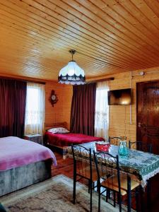 a bedroom with two beds and a table with chairs at Family Hotel Maia - Cемейная гостиница Майя in Dashbashi