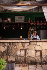 un homme assis dans un bar parlant sur un téléphone portable dans l'établissement Pousada Brisa da Serra, à Tiradentes