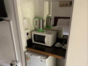 eine Küche mit einer Mikrowelle und einem Mixer auf der Theke in der Unterkunft Bogotá in Pietermaritzburg