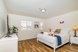 een witte slaapkamer met een bed met knuffels erop bij Family Friendly 4B2 5B Condo in El Monte