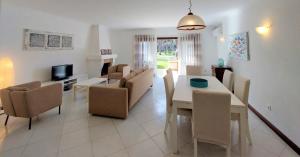 een eetkamer en een woonkamer met een tafel en stoelen bij Vilamouratenis 'Blue' by SAPvillas in Vilamoura
