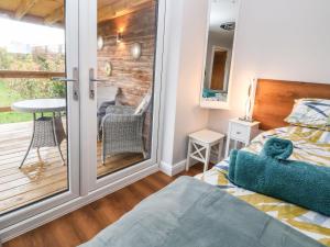 um quarto com uma varanda com uma cama e uma mesa em Meols Holiday Lodge em Wirral