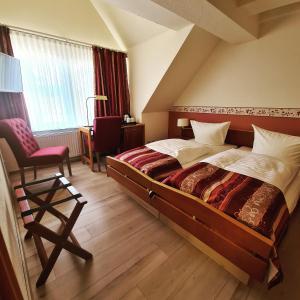 a bedroom with a bed and a chair and a window at Nordischer Hof in Krakow am See