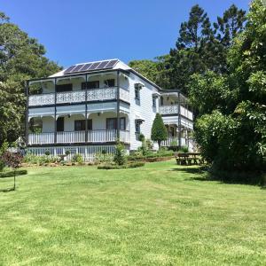a large white house with a lawn in front of it at Middleton House Maleny in Witta