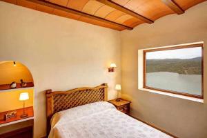 a bedroom with a bed and a large window at Masia Mas d'en Bosch in Lleida