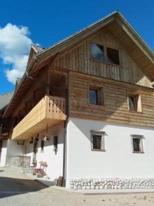 a house with a wooden roof on top of it at Kmetija Muže in Bled