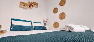 a bedroom with a bed with a green blanket and pillows at Kato Yialos Paros in Parikia