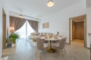 a dining room and living room with a table and chairs at Marco Polo - Stunning 2 BR With Marina Views, Huge Pool & Gym in Dubai