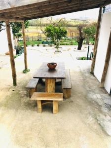 einem Picknicktisch aus Holz mit einer Schüssel darüber in der Unterkunft Casa Da Várzea in Torres Vedras
