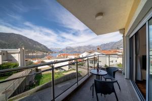 a balcony with a table and chairs and a view at Ladybug in Dobrota