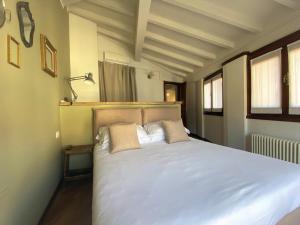 una camera da letto con un grande letto bianco con due cuscini di Il Molo Di Hotel Villa Aurora a Lezzeno