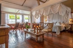 a living room with a bed and a table with candles at Pousada Brisa da Serra in Tiradentes