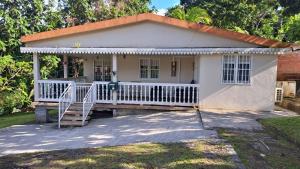 Cette petite maison blanche dispose d'une terrasse couverte. dans l'établissement Villa Délia, au Lamentin