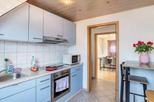 a kitchen with white cabinets and a sink and a microwave at am Hirnach in Sindelfingen