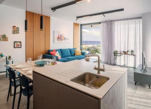 eine Küche mit einem Waschbecken und ein Wohnzimmer in der Unterkunft Gaia Seaview Apartment 1 in Larnaka