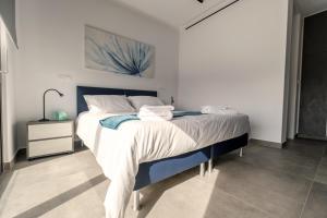 a bedroom with a large bed with white sheets at Gaia Seaview Apartment 1 in Larnaka