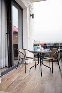 een tafel en stoelen op een balkon met uitzicht bij СПА Хотел Романтика in Sarnitsa