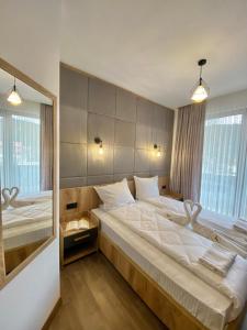 een slaapkamer met een groot bed en een grote spiegel bij СПА Хотел Романтика in Sarnitsa
