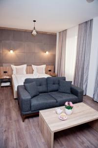 een woonkamer met een bank en een bed bij СПА Хотел Романтика in Sarnitsa