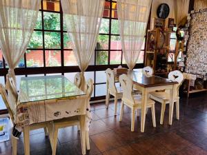 a dining room with a table and chairs and windows at Shui Tian Yi Yishujia Homestay in Puli