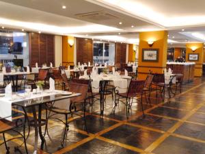 a dining room with white tables and chairs at Pestana Rovuma in Maputo