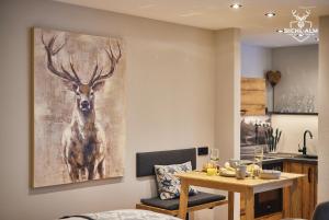 a dining room with a painting of a deer on the wall at Chalet Gamsblüh in Oberstaufen