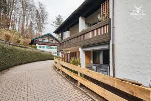 ein Haus mit einem Holzzaun neben einem Gebäude in der Unterkunft Chalet Gamsblüh in Oberstaufen
