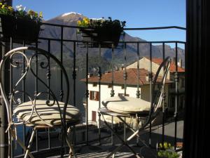 einen Balkon mit 2 Stühlen und Blick auf ein Haus in der Unterkunft Il Molo Di Hotel Villa Aurora in Lezzeno