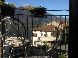a balcony with two chairs and a view of a house at Il Molo Di Hotel Villa Aurora in Lezzeno