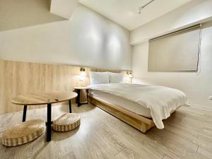 a bedroom with a large bed and a table at 茗居 House in Taichung