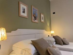 a bedroom with two beds and two lamps and pictures on the wall at Il Molo Di Hotel Villa Aurora in Lezzeno +34 photos