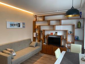 sala de estar con sofá y TV de pantalla plana en Apartma Eli, en Bled